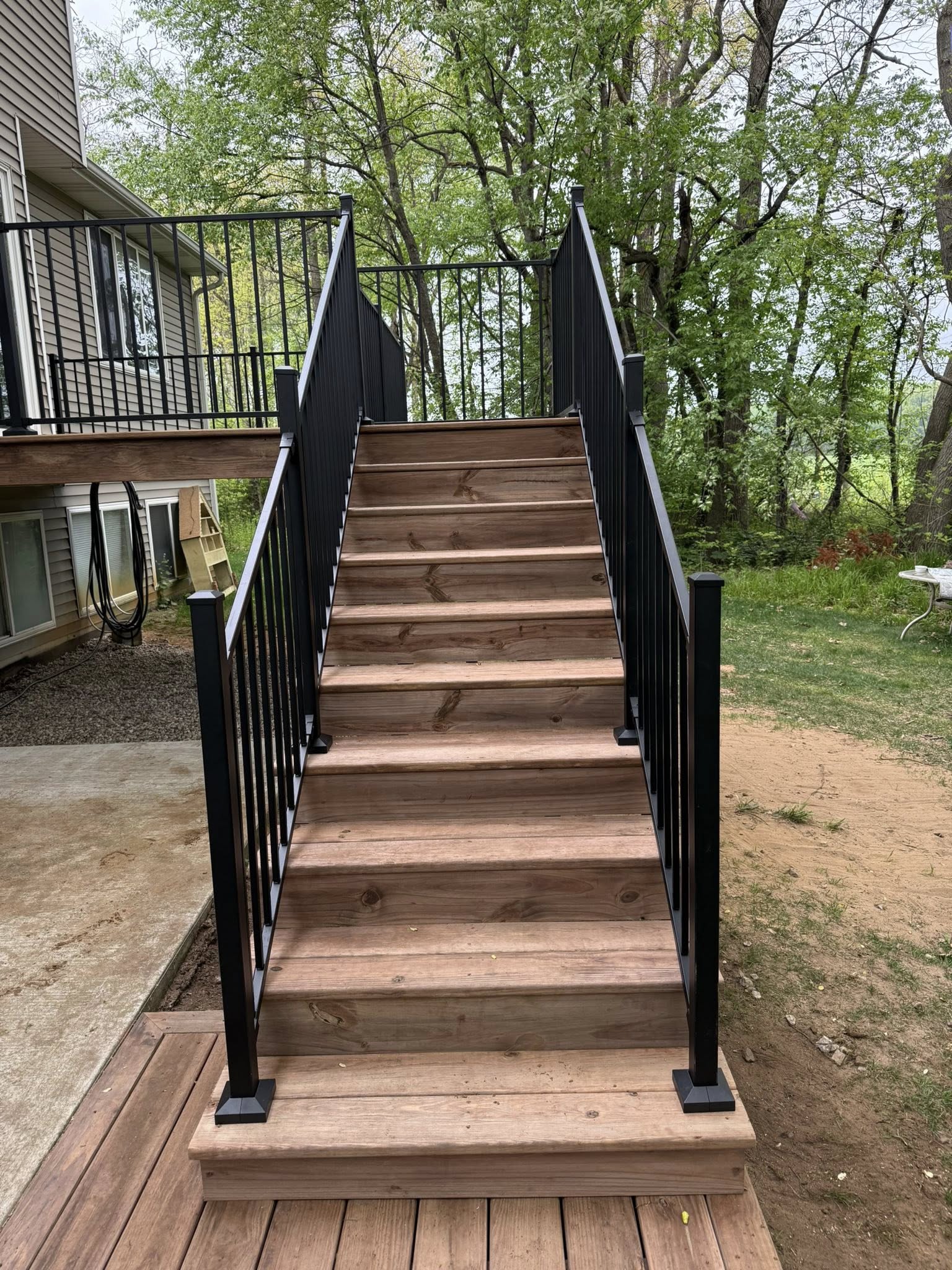 Wood deck stairs with black metal railing
